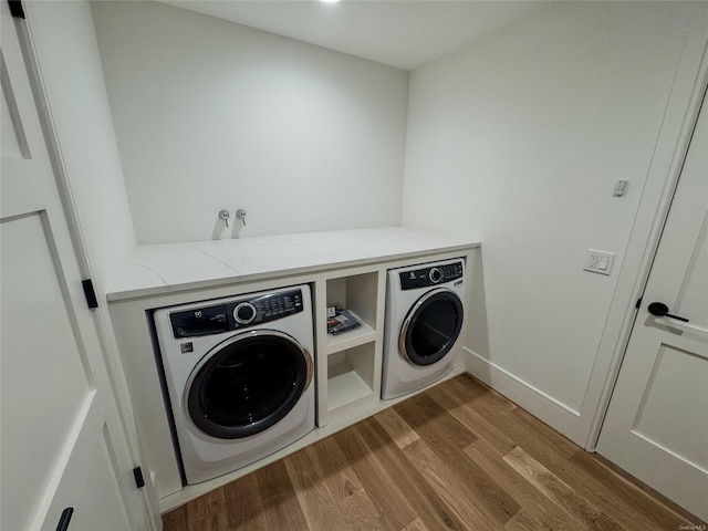 clothes washing area with separate washer and dryer and light hardwood / wood-style flooring