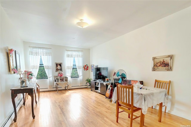 dining room with light hardwood / wood-style floors and a baseboard heating unit