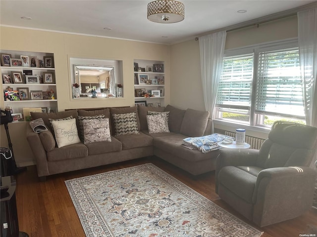 living room featuring hardwood / wood-style floors, built in features, and ornamental molding