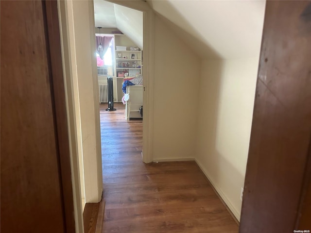 hall featuring radiator heating unit, dark wood-type flooring, and vaulted ceiling