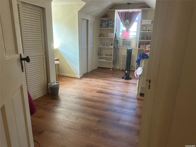 hallway featuring cooling unit, vaulted ceiling, and hardwood / wood-style flooring