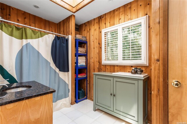 bathroom featuring vanity and wooden walls