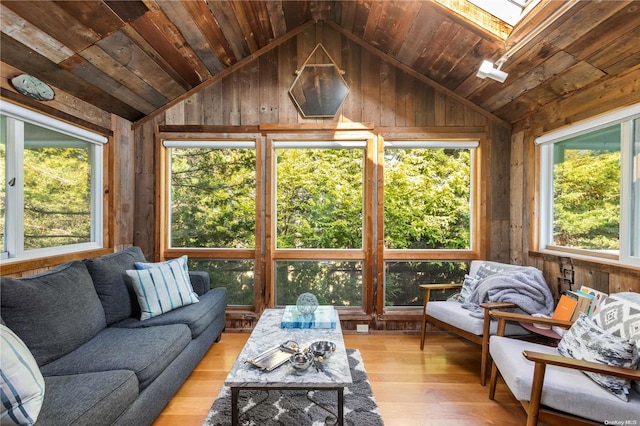 sunroom / solarium with wooden ceiling, lofted ceiling with skylight, and a healthy amount of sunlight