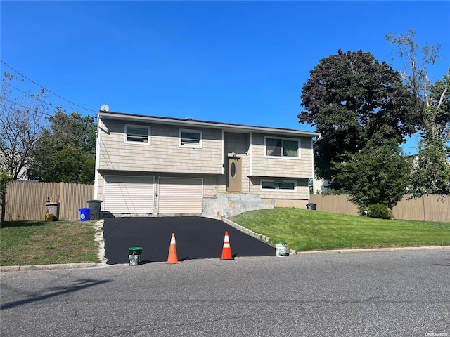 bi-level home with a front yard and a garage