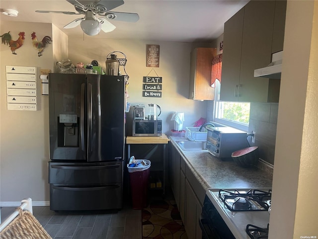 kitchen with black fridge, sink, ceiling fan, range, and extractor fan