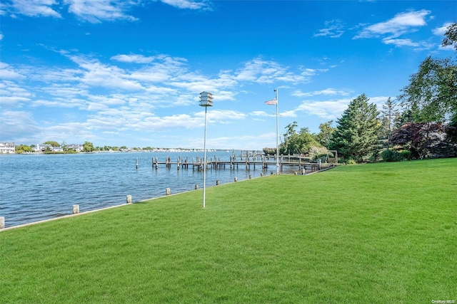 view of dock with a yard and a water view