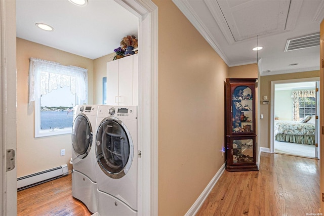 washroom featuring ornamental molding, baseboard heating, a wealth of natural light, and light hardwood / wood-style flooring