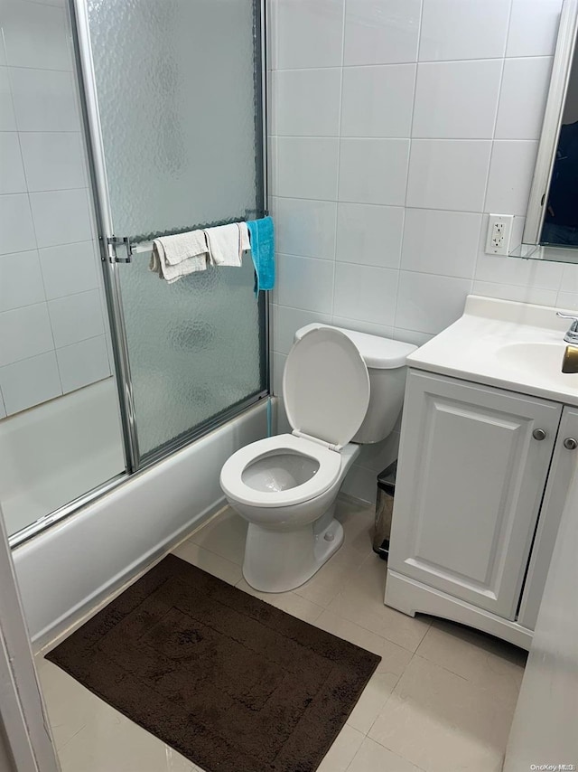 full bathroom featuring tasteful backsplash, vanity, tile walls, enclosed tub / shower combo, and tile patterned flooring