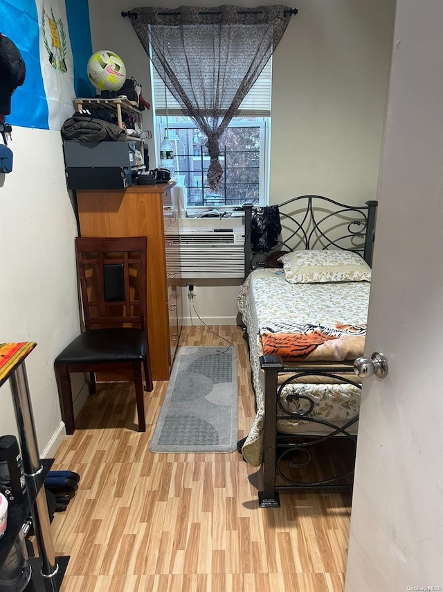 bedroom with cooling unit and wood-type flooring