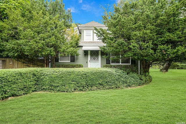 view of property hidden behind natural elements with a front lawn