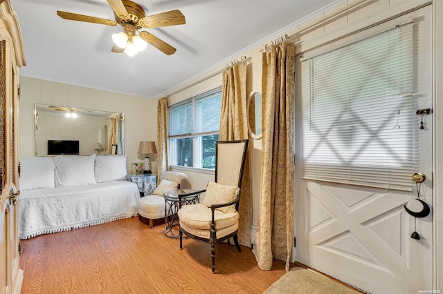 bedroom featuring ceiling fan, light hardwood / wood-style flooring, and ornamental molding