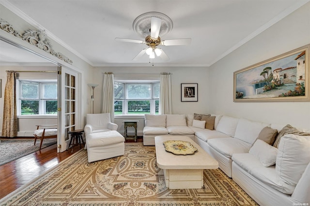 living room featuring hardwood / wood-style floors, ceiling fan, and crown molding