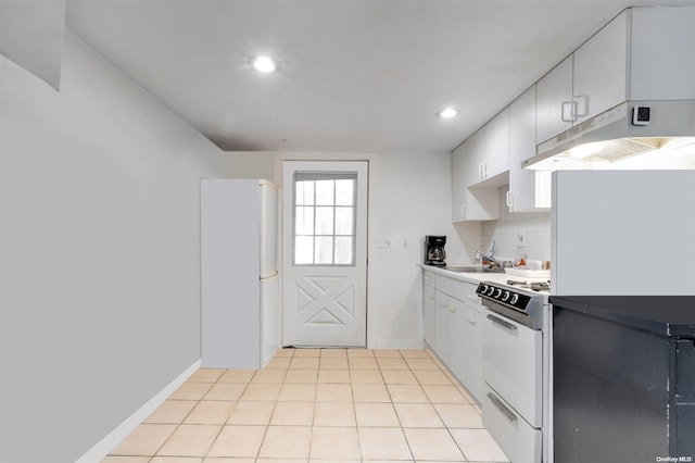 kitchen featuring white range oven, tasteful backsplash, white cabinets, and light tile patterned floors