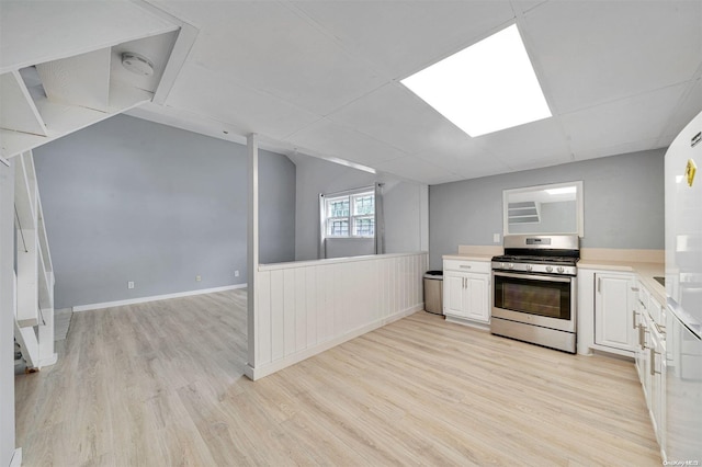 kitchen featuring gas stove, white cabinetry, and light hardwood / wood-style floors