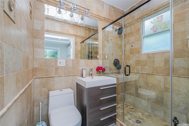 bathroom featuring walk in shower, vanity, tile walls, and toilet