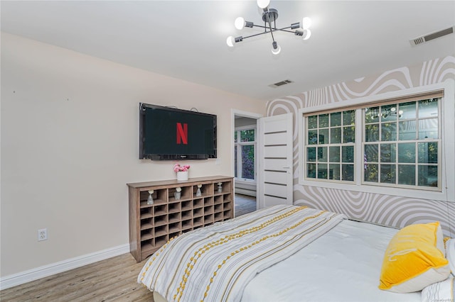 bedroom featuring hardwood / wood-style flooring and an inviting chandelier