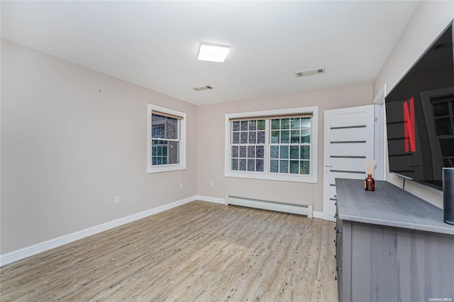 interior space featuring light hardwood / wood-style floors, baseboard heating, and a wealth of natural light