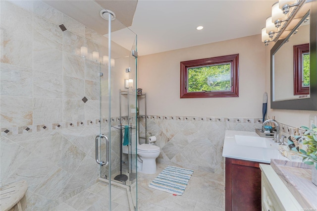 bathroom featuring an enclosed shower, vanity, a healthy amount of sunlight, and tile walls