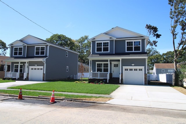 view of property featuring a porch, a garage, and a front yard