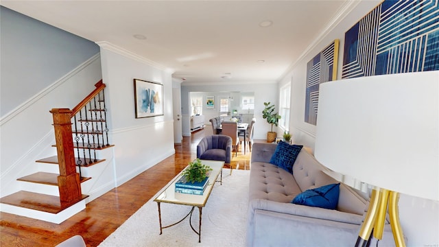 living room with baseboards, stairs, ornamental molding, and wood finished floors