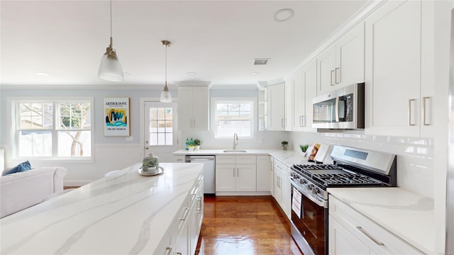 kitchen featuring dark wood-style flooring, stainless steel appliances, visible vents, white cabinetry, and a sink