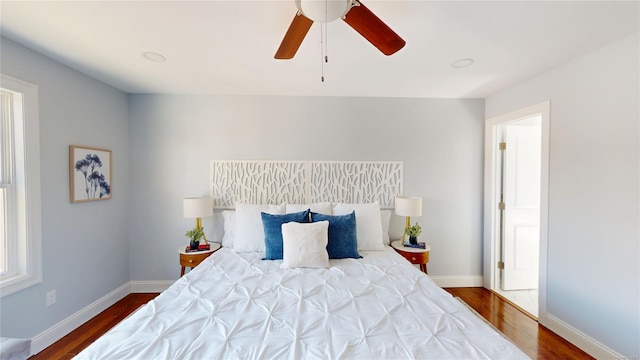 bedroom with ceiling fan, baseboards, and wood finished floors