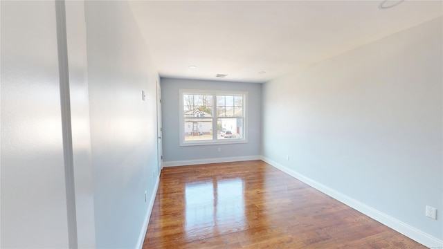 unfurnished room featuring wood finished floors and baseboards