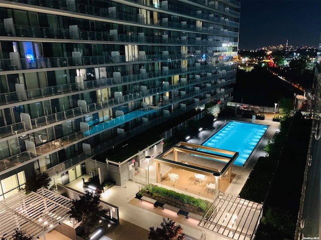 view of pool at twilight