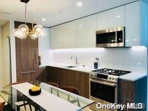 kitchen with appliances with stainless steel finishes, pendant lighting, and sink