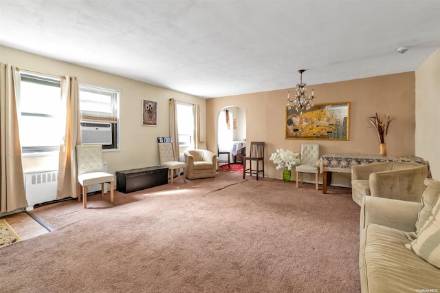 living room with carpet, cooling unit, radiator, and an inviting chandelier