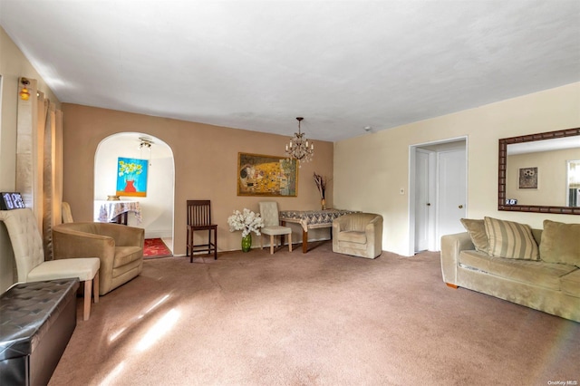 carpeted living room with an inviting chandelier