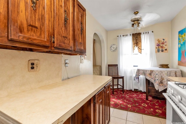 kitchen featuring decorative light fixtures, white range oven, ceiling fan, and light tile patterned flooring