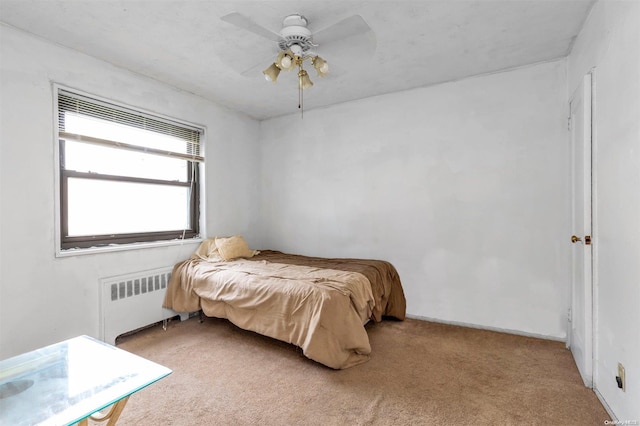 carpeted bedroom with radiator and ceiling fan