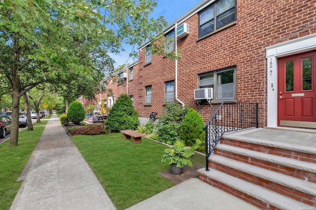 160-51 17th Ave Lower, Lower, Whitestone, NY 11357 - view of exterior entry with brick siding, a lawn, and cooling unit
