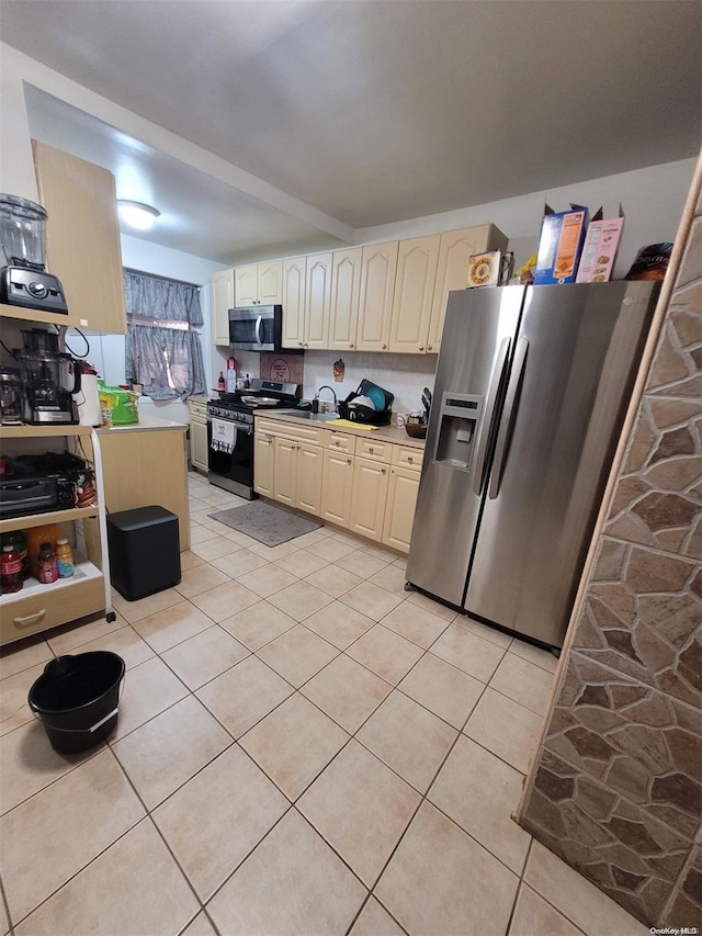 kitchen featuring backsplash, cream cabinets, and stainless steel appliances