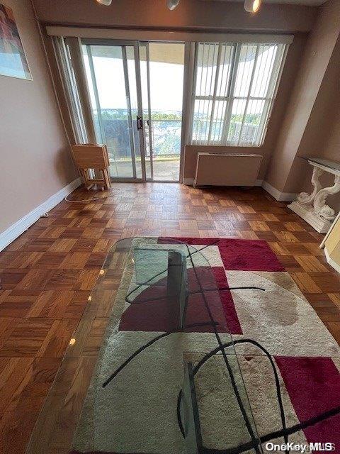 interior space featuring a healthy amount of sunlight and dark parquet flooring