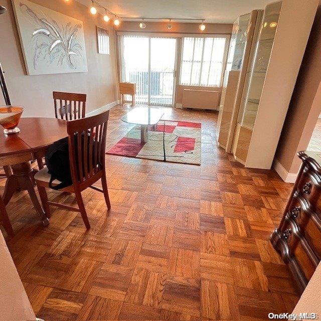 dining area with parquet floors and track lighting