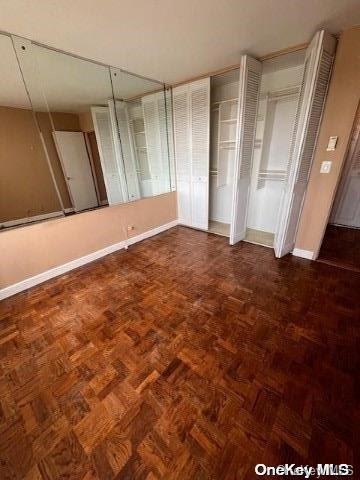 unfurnished bedroom with dark parquet floors