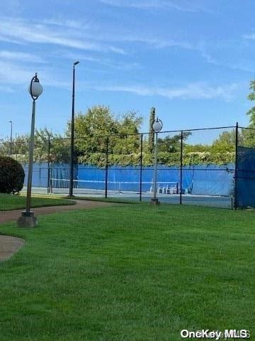 view of basketball court featuring a yard, a water view, and tennis court