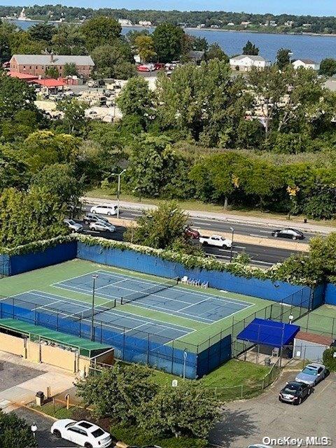 view of tennis court featuring a water view