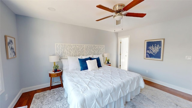 bedroom with ceiling fan, baseboards, and wood finished floors