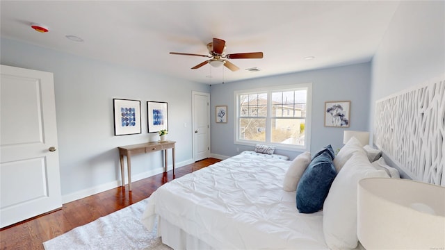 bedroom featuring a ceiling fan, wood finished floors, visible vents, and baseboards