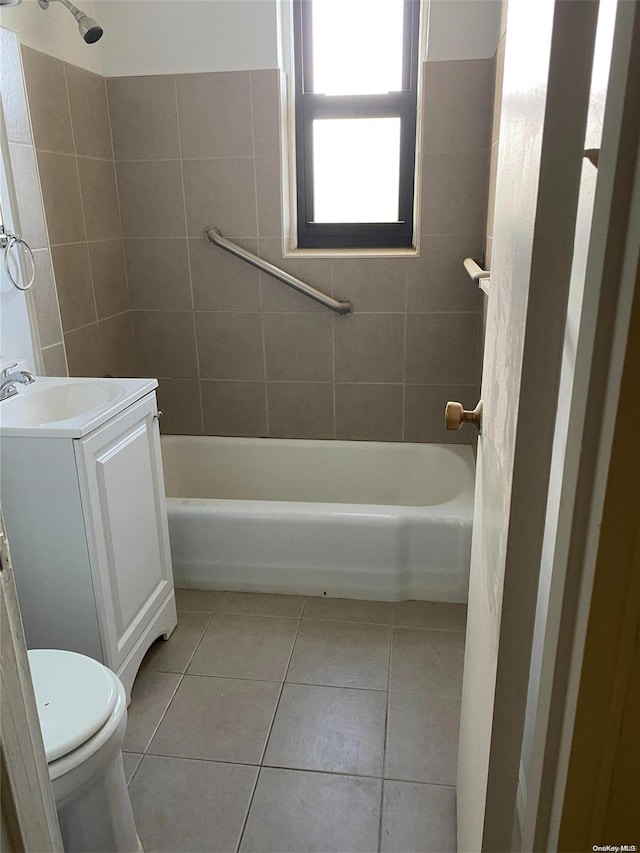 full bathroom featuring tile patterned floors, tiled shower / bath, vanity, and toilet