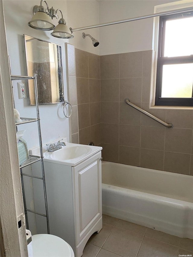 full bathroom featuring tile patterned flooring, vanity, tiled shower / bath combo, and toilet