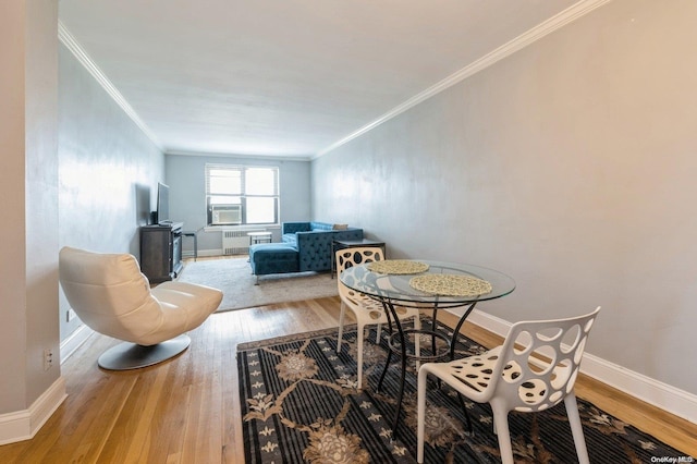 dining area featuring hardwood / wood-style floors and crown molding