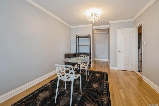 dining space with a chandelier, light hardwood / wood-style flooring, and ornamental molding