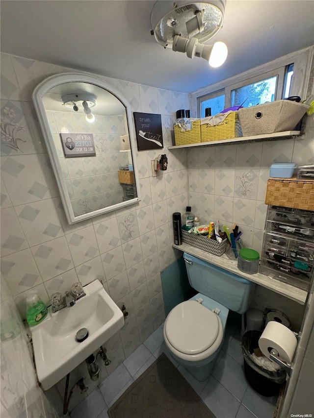 bathroom featuring tile patterned floors, sink, toilet, and tile walls