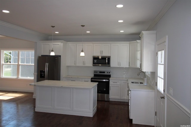 kitchen with sink, a center island, dark hardwood / wood-style flooring, decorative light fixtures, and appliances with stainless steel finishes