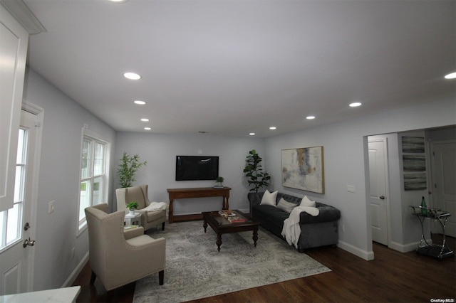 living room with plenty of natural light and dark wood-type flooring