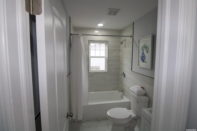 bathroom featuring shower / bath combination with curtain and toilet